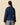 A person wearing a Women’s Fitted Lace Collar Button Down Shirt Navy, featuring a navy blue double-collared design with green vertical pinstripes and a large, scalloped floral-embroidered collar.