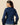 A woman wears a Women’s Fitted Lace Collar Button Down Shirt Navy, a navy button-up top with thin green vertical stripes and a large, scalloped collar featuring tonal floral embroidery.