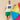 A man wearing an Open Weave Sweater Jersey Cream with the number 99 and green shorts leans against a large, colorful inflatable beach ball.