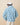 A person seen from the back wearing a blue and white Warm & Wonderful Sheep Sherpa Jacket featuring a repeating black sheep pattern.