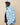 A person wearing a Warm & Wonderful Sheep Sherpa Jacket Blue, a zip-up sherpa fleece jacket with a repeating pattern of white sheep on a light blue background.