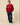 A man wearing a Warm & Wonderful Men’s Cotton Cable Sheep Sweater Burgundy with navy trousers and white sneakers.