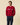 A man wearing a Warm & Wonderful Men’s Cotton Cable Sheep Sweater Burgundy featuring a row of white sheep with one black sheep across the chest.
