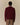 A person seen from behind wears a burgundy Chenille Patch Cotton Sweater by Rowing Blazers over a light-colored collared shirt with brown trousers.