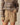A person wears Ollie Herringbone Casual Shorts Camel by Rowing Blazers with a colorful long-sleeve sweater, standing with one hand in their pocket against a plain background.