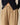 Model wears the Cath Herringbone Pant Camel by Rowing Blazers, featuring a drawstring waistband. The image is cropped to show only the lower torso, styled with a dark navy sweater with black buttons.