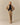 A woman stands against a beige background wearing the Rowing Blazers York Herringbone Funnel Neck Jacket Camel with matching wide-leg pants, a black button-up top, and black open-toed shoes, hands on hips facing forward.