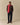 A person faces forward in dark pants, boat shoes, a Princess Diana sweater, and the Warm & Wonderful Cotton Sheep Scarf Diana Red. The background is plain beige.
