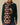 A Cotton Sheep Scarf Brown featuring a repeating pattern of white sheep and one black sheep draped over a person wearing a green Warm & Wonderful sweater with a cartoon character graphic.