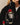 A person wearing a black Rowing Blazers x Paddington™ Tuxedo Paddington Classic Sherpa jacket featuring an embroidered Paddington bear in a tuxedo and red hat.