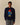 A person wears a Rowing Blazers x Paddington™ Paddington Bear Cashmere Sweater in navy, a wool-and-cashmere crewneck featuring an intarsia illustration of Paddington Bear holding a jar of marmalade.