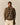 Man wearing a plaid jacket with a fair isle patterned sweater underneath, Standing on a beige wall.