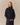 A person wears an oversized navy blue Kaia Shawl Sweater Navy with a wide shawl collar.