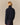 Back view of a person wearing a navy Kaia Shawl Sweater with a ribbed shawl collar over a green and red plaid skirt.