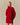 A person wearing a red Korryn Turtleneck Mini Sweater Dress with a ribbed skirt.