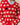 Person wearing the Warm & Wonderful Diana Edition Cotton Linen V-Neck Sheep Sweater Red—a red sweater with a white sheep pattern and one black sheep—over a blue collared shirt. Person’s head not visible.