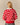 Back view of a person wearing a Warm & Wonderful Wool Diana Edition Sheep Sweater Diana Red over a white collared shirt, featuring a red knit with a grid of white sheep.
