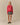 A person wears a Warm & Wonderful Warm & Wonderful Wool Diana Edition Sheep Sweater Diana Red, styled over a white collared shirt with a black and white plaid skirt and black Mary Jane shoes.