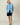 A person wearing a black Sheep Sherpa Jacket Blue and navy shorts.
